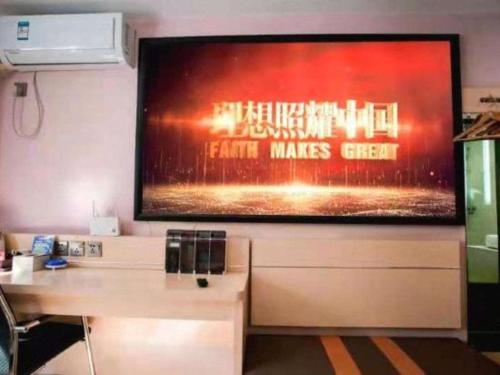 a large flat screen tv hanging on a wall at 7 Days Premium Hohhot Hailiang Square in Hohhot
