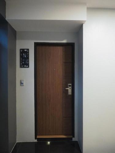 a wooden door in a room with a wall at The Nest Hotel in Nakhon Ratchasima