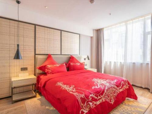a bedroom with a red bed and a large window at Echarm Hotel Zibo Gaoqing Zhongcheng Inernational in Zibo