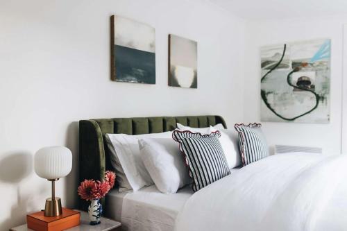 una camera con letto bianco e cuscini di Coromandel Homestead, Berrima a Berrima