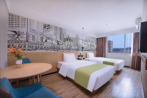 a hotel room with two beds and a table at City Comfort Inn Nanning Yudong Jinxiang Metro Station in Nanning