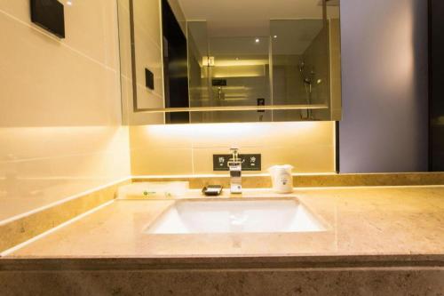 a sink in a bathroom with a mirror and a sink sidx sidx sidx at City Comfort Inn Nanning Shuangyong Road Guangxi Medical University in Nanning