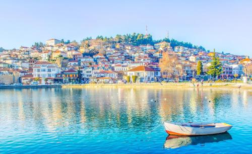a boat in the water in front of a city at Villa Sofijana in Ohrid