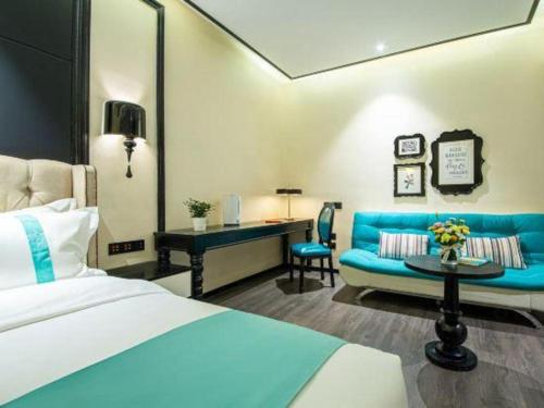 a hotel room with a bed and a blue couch at Xana Hotelle Nanchang Tengwang Pavilion Wanshougong in Nanchang