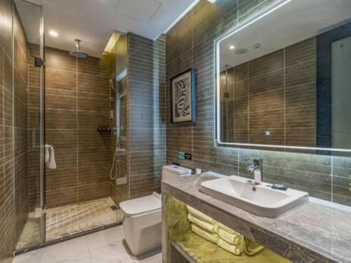 a bathroom with a sink and a shower and a toilet at Xana Hotelle Nanchang Tengwang Pavilion Wanshougong in Nanchang