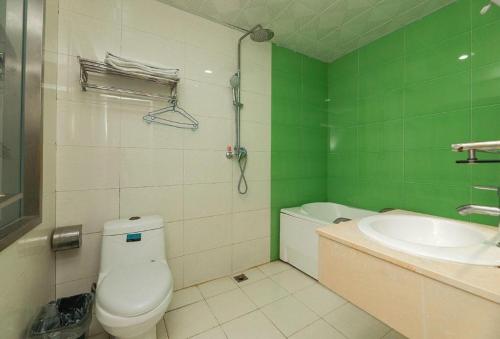 un bagno verde con un water e un lavandino di PAI Hotels Beijing Tongzhou Majuqiao a Pechino