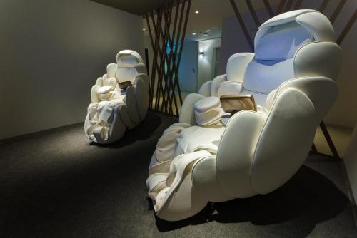 a row of white chairs in a room at グリーンサンホテル in Shimo-suwa