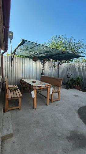 a ping pong table and benches in a backyard at Stuffstock Hostel in Sulina