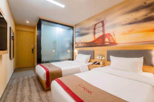 a hotel room with two beds and a painting at Thank Inn Hotel Jiangsu Wuxi High-Tech Zone Ruigang Pedestrian Street in Wuxi