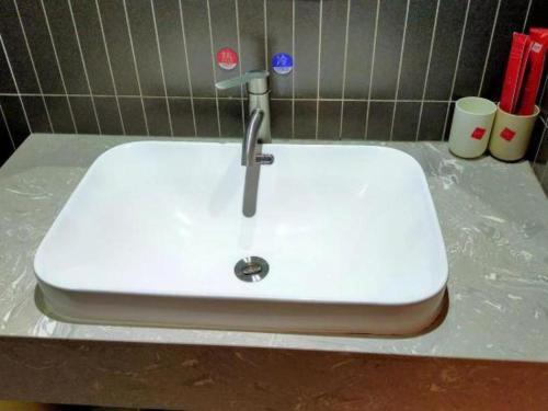 a white sink with a faucet on a counter at Thank Inn Plus Hotel Guangdong Yunfu Luoding City Municipal in Yunfu
