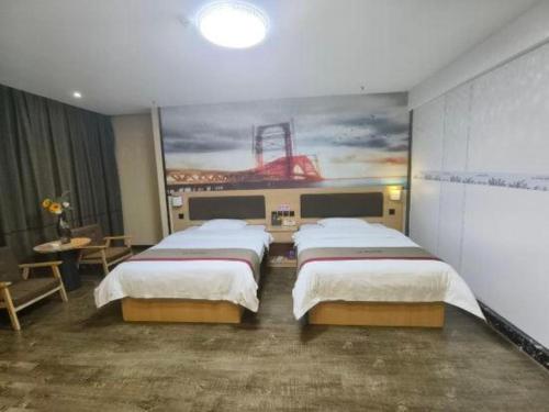 a bedroom with two beds and a painting on the wall at Thank Inn Plus Hotel Guangdong Yunfu Luoding City Municipal in Yunfu