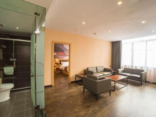 a living room with a couch and a table at Thank Inn Plus Hotel Guangdong Yunfu Luoding City Municipal in Yunfu