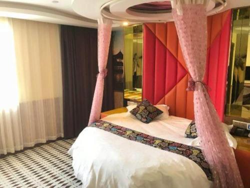 a bedroom with a canopy bed with pink curtains at Ease Hotel Shanghai Chuanhuan Nan Road Chuansha Metro Station in Shanghai