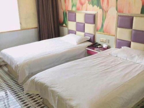 two beds in a hotel room next to each other at Ease Hotel Shanghai Chuanhuan Nan Road Chuansha Metro Station in Shanghai