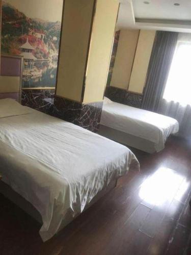 a hotel room with two beds and a window at Ease Hotel Shanghai Chuanhuan Nan Road Chuansha Metro Station in Shanghai