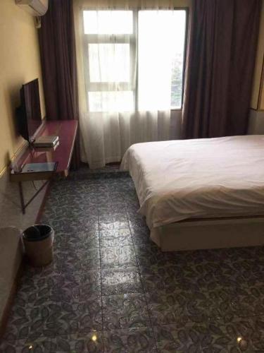 a hotel room with a bed and a window at Ease Hotel Shanghai Chuanhuan Nan Road Chuansha Metro Station in Shanghai