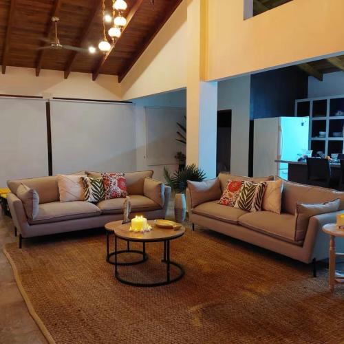a living room with two couches and a table at Casa Nosara a 10 minutos de las playas en auto in Nosara