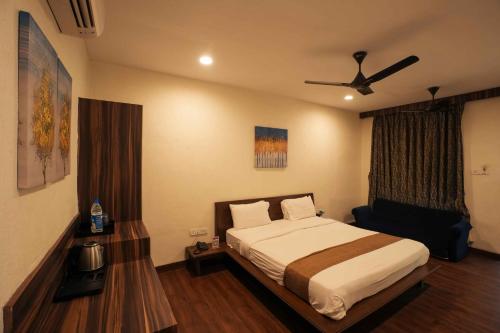 a bedroom with a bed and a ceiling fan at Adamo The Village in Matheran
