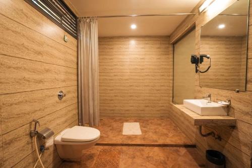a bathroom with a toilet and a sink at Adamo The Village in Matheran