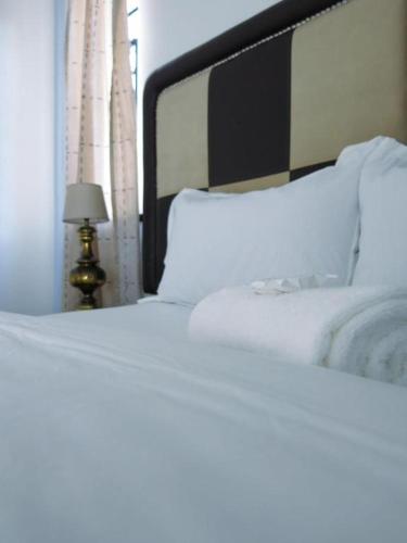 a bedroom with a bed with white sheets and a lamp at 33 Goulborn street Goodwood in Cape Town