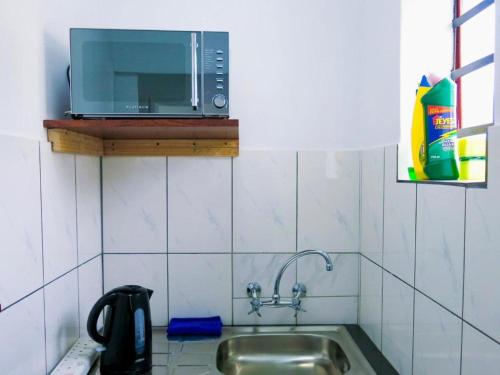 a kitchen with a sink and a microwave at 33 Goulborn street Goodwood in Cape Town