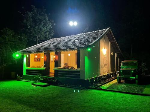a small house at night with green lights at Yuk's villa in Gūdalūr