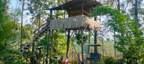 a tree house in the middle of a forest at Yuk's villa in Gūdalūr