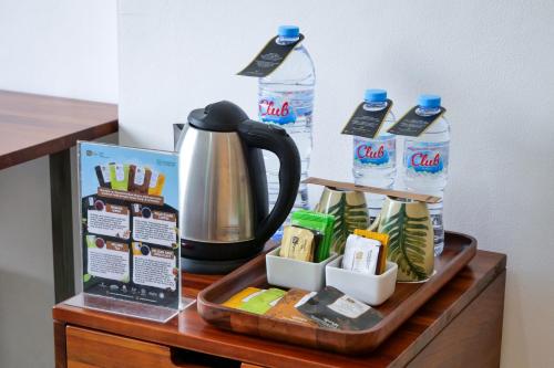 a table with a coffee maker and a tea kettle at Metro Park View Hotel Kota Lama Semarang in Semarang