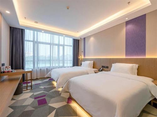 a hotel room with two beds and a large window at Lavande Hotel Foshan Shunde Daliang Qinghuiyuan Shihu Road in Shunde