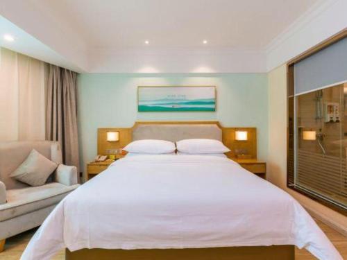 a bedroom with a large white bed and a window at Vienna Hotel Guangdong Foshan Shunde Longjiang Material City in Shunde