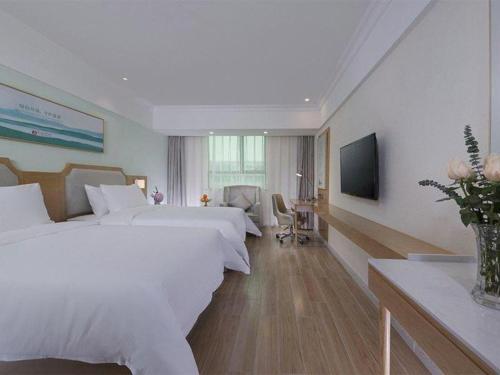 a hotel room with two beds and a television at Vienna Hotel Guangdong Foshan Shunde Longjiang Material City in Shunde