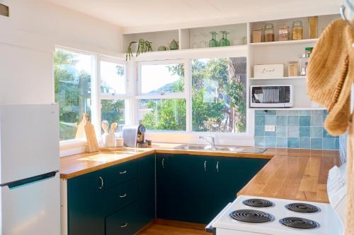 a kitchen with blue cabinets and a white refrigerator at Sweet Az in Bicheno