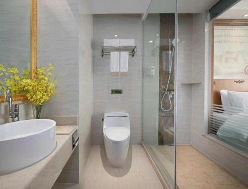 ein Badezimmer mit Toilette, Waschbecken und Dusche in der Unterkunft Vienna Hotel Hebei Hengshui High-Speed Railway Station in Hengshui