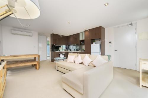 a living room with a white couch and a table at Modern Stay in Campbell Near Canberra Centre - Hosted by Canstay in Campbell