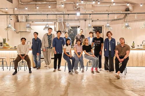 a group of people posing for a picture in a room at GRAND HOSTEL LDK Tokyo Nishikasai -GRAND OPENING In May 2025- in Tokyo
