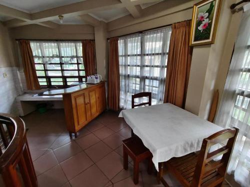 a room with a table and a bench and windows at Sapadia Hotel Parapat in Parapat