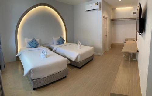 two beds in a room with an archway at Thong Prachok Hotel in Sakon Nakhon
