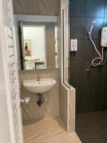 a bathroom with a sink and a mirror at Thong Prachok Hotel in Sakon Nakhon