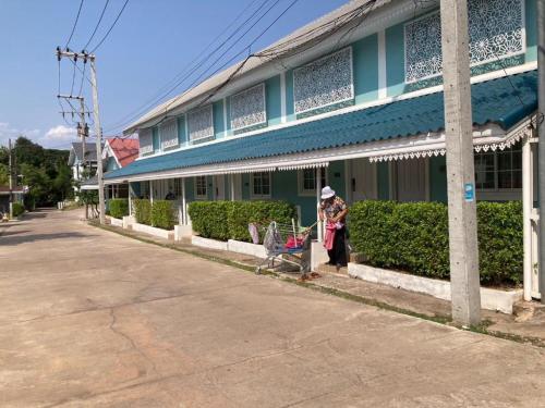 a woman pushing a shopping cart in front of a building at Thong Prachok Hotel in Sakon Nakhon