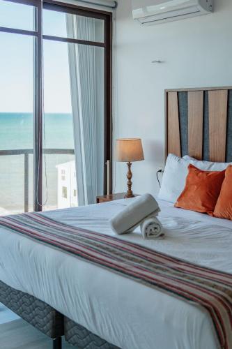 a bedroom with a bed with a view of the ocean at Penthouse en Chicxulub in Chicxulub