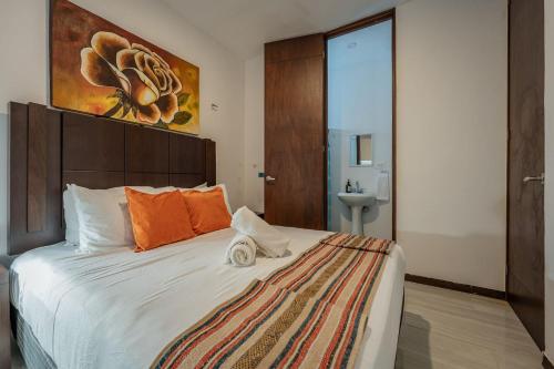 a bedroom with a large bed with orange pillows at Penthouse en Chicxulub in Chicxulub