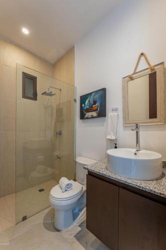 a bathroom with a toilet and a sink and a shower at Penthouse en Chicxulub in Chicxulub