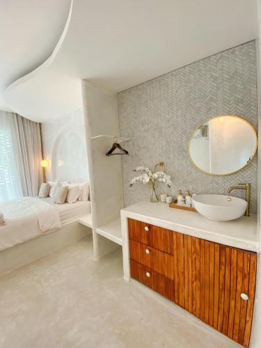 a bathroom with a sink and a bed and a mirror at Evelia Kohsamed in Ao Phutsa