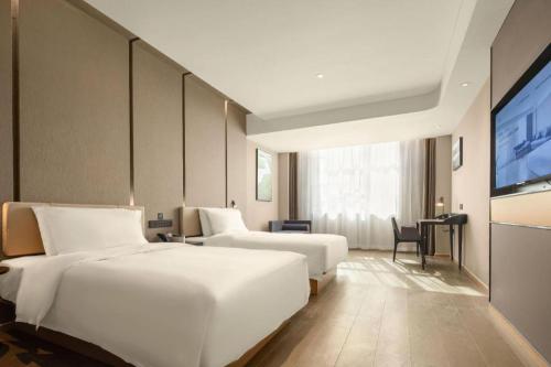 a hotel room with two beds and a flat screen tv at Atour Hotel Taiyuan Inner Ring in Taiyuan