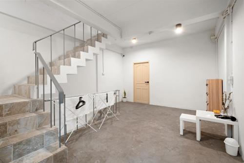 a room with a staircase and a white wall at Kuha Phuket Old Town in Phuket Town