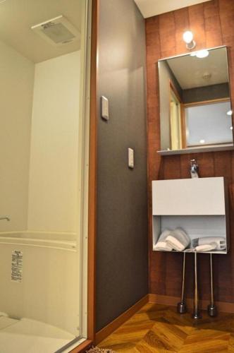 a bathroom with a shower and a sink and a mirror at HOSTEL LUND I -Oimachi- in Tokyo