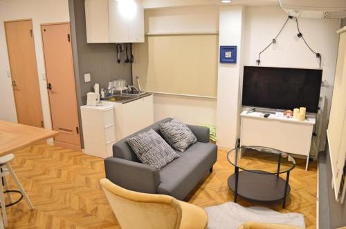 a living room with a couch and a tv at HOSTEL LUND I -Oimachi- in Tokyo