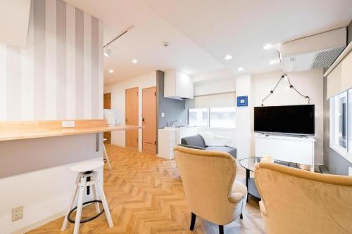 a kitchen and living room with a bar and chairs at HOSTEL LUND I -Oimachi- in Tokyo