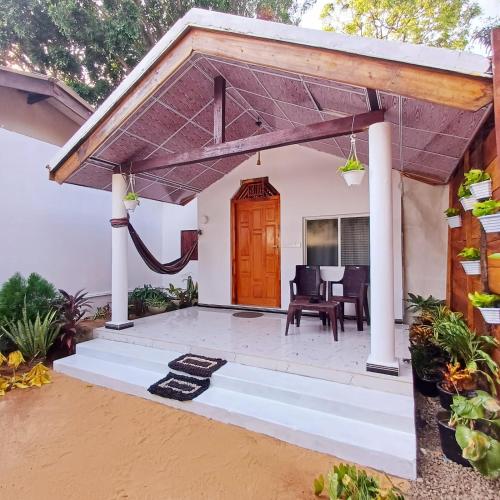 a home with a patio with a wooden door at Salty Palm Villa in Arugam Bay