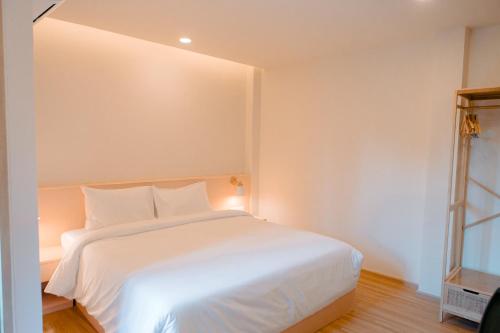 a bedroom with a white bed and a window at Baan Cocoa Boutique Hotel in Natai Beach